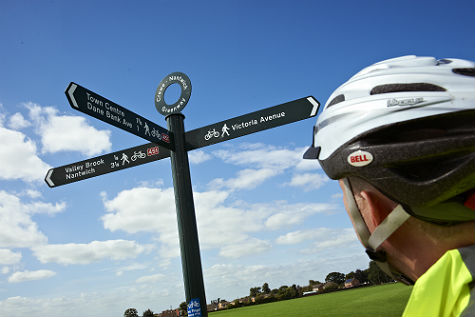 A cyclist looking at a signpost in Crewe