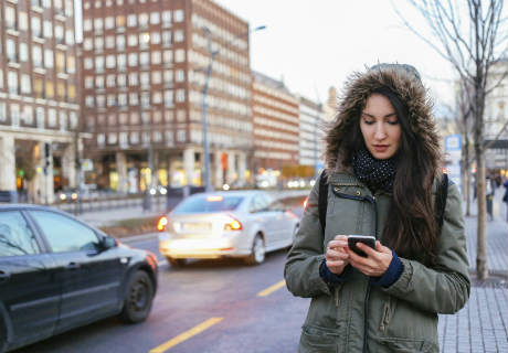 Winter portrait of a woman in the city calling taxi