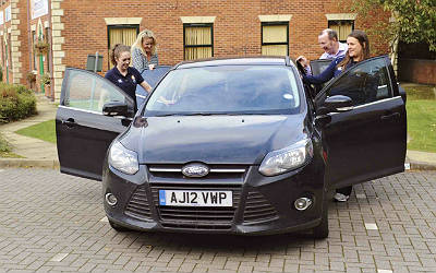 A family get into a parked car