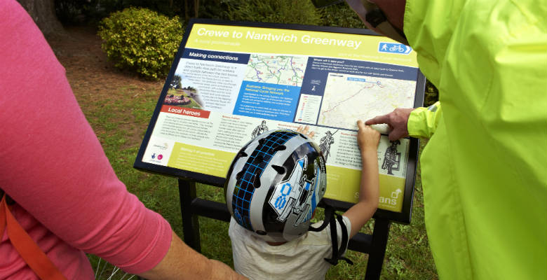 A child and parents looking at a cycle route map