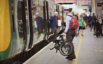 A man boards a train carrying his bicycle