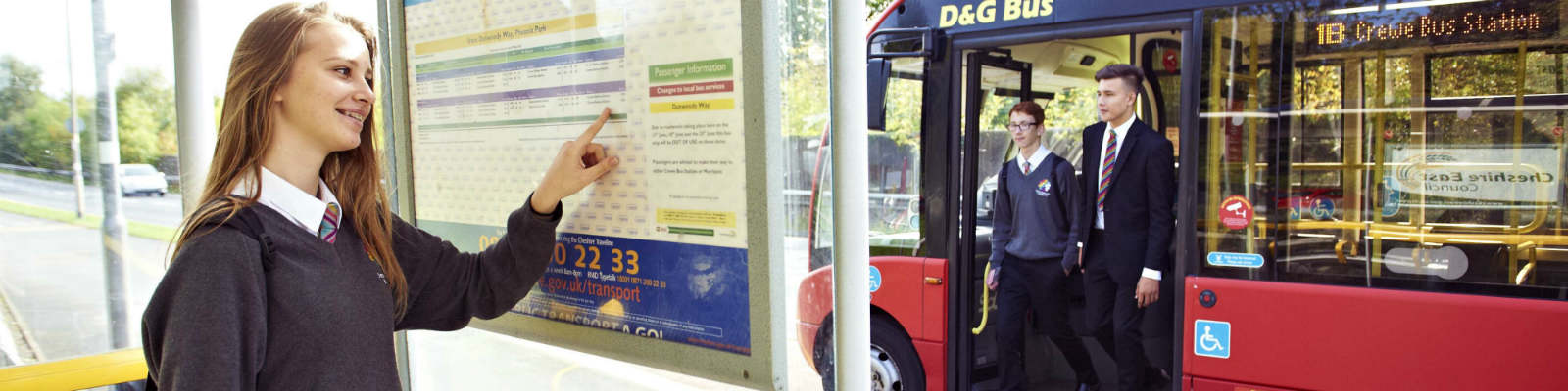 A school girl looks at a bus timetable