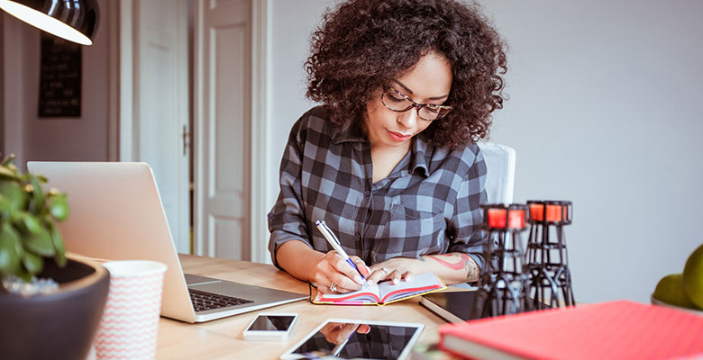 Woman in a home office taking notes